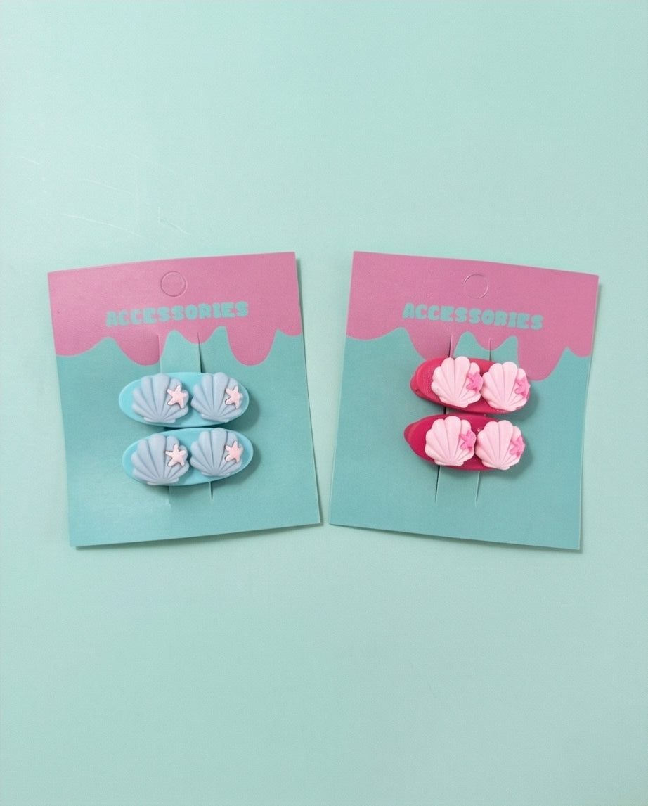 Two sets of hair accessories in packaging on a light blue background