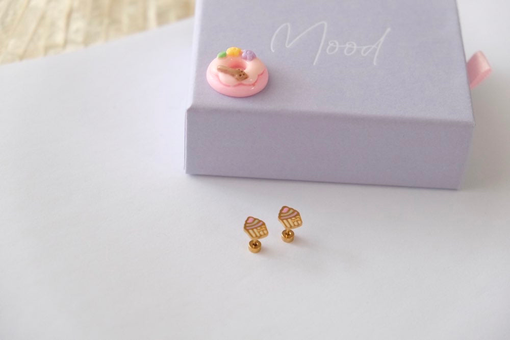 Kids Gold earrings on a white surface with a pink box labeled 'Mood' in the background.