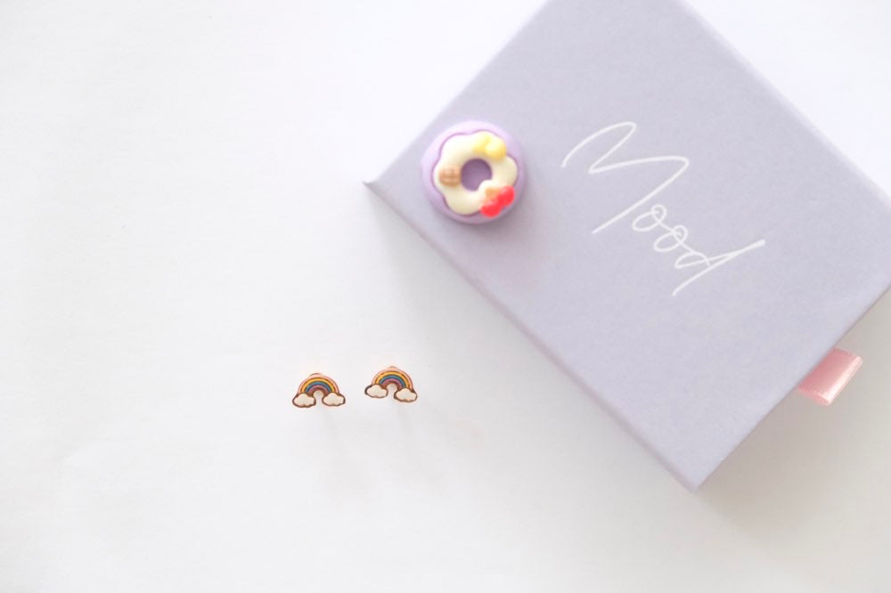 rainbow earrings on a white surface with a 'Mood' box in the background.