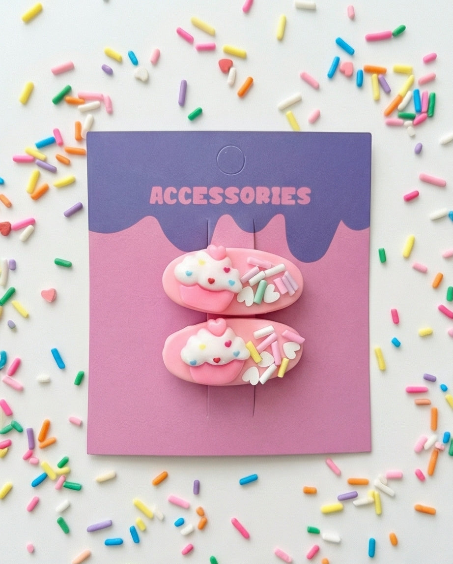 Pink accessories with sprinkles on a pink and purple card surrounded by colorful sprinkles.